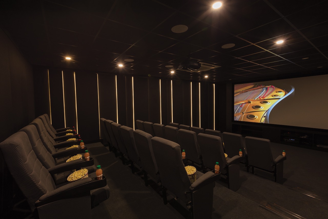 Architectural 4K Screening Room with Symmetrical Backlit Ribs and Tiered Seating